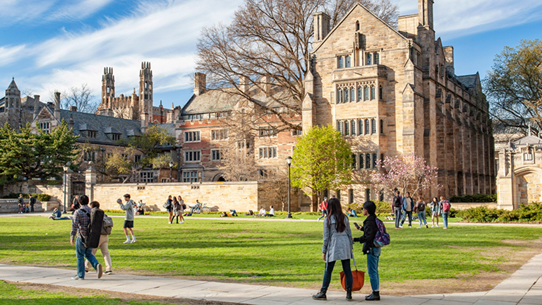 picture of yale campus with people walking on it.